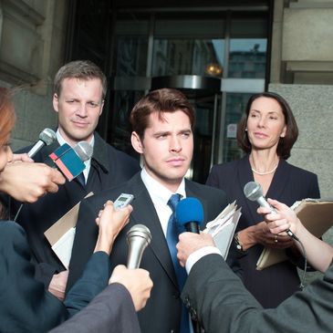 Businessman giving a press interview outside an office building.