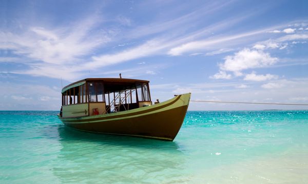 Dhoni dive boat moored in beautiful blue water