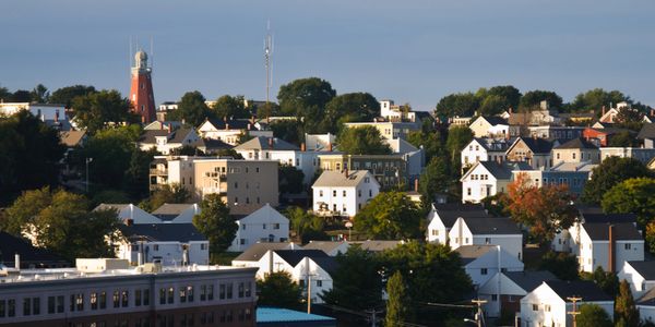 A scenic view of a residential neighborhood with a prominent red lighthouse tower.