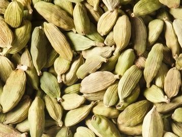 Close-up of dried green cardamom pods clustered together.