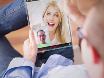Man video chatting with a woman on a tablet.