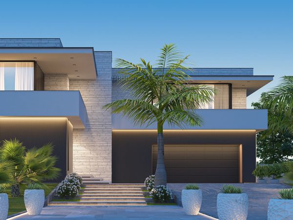 Modern luxury home with minimalist design and palm trees at dusk.