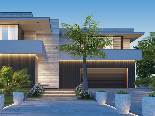 Modern luxury home with minimalist design and palm trees at dusk.
