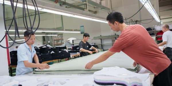 Workers handling fabric in a textile factory.
