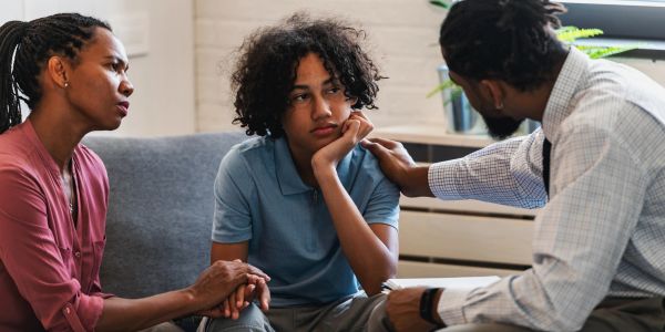 Parents comforting a sad teenage child.