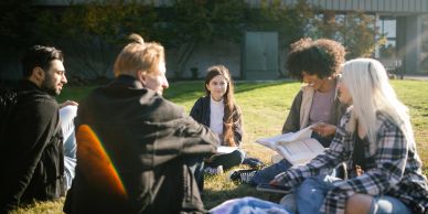 Group of students studying outdoors on a sunny day.