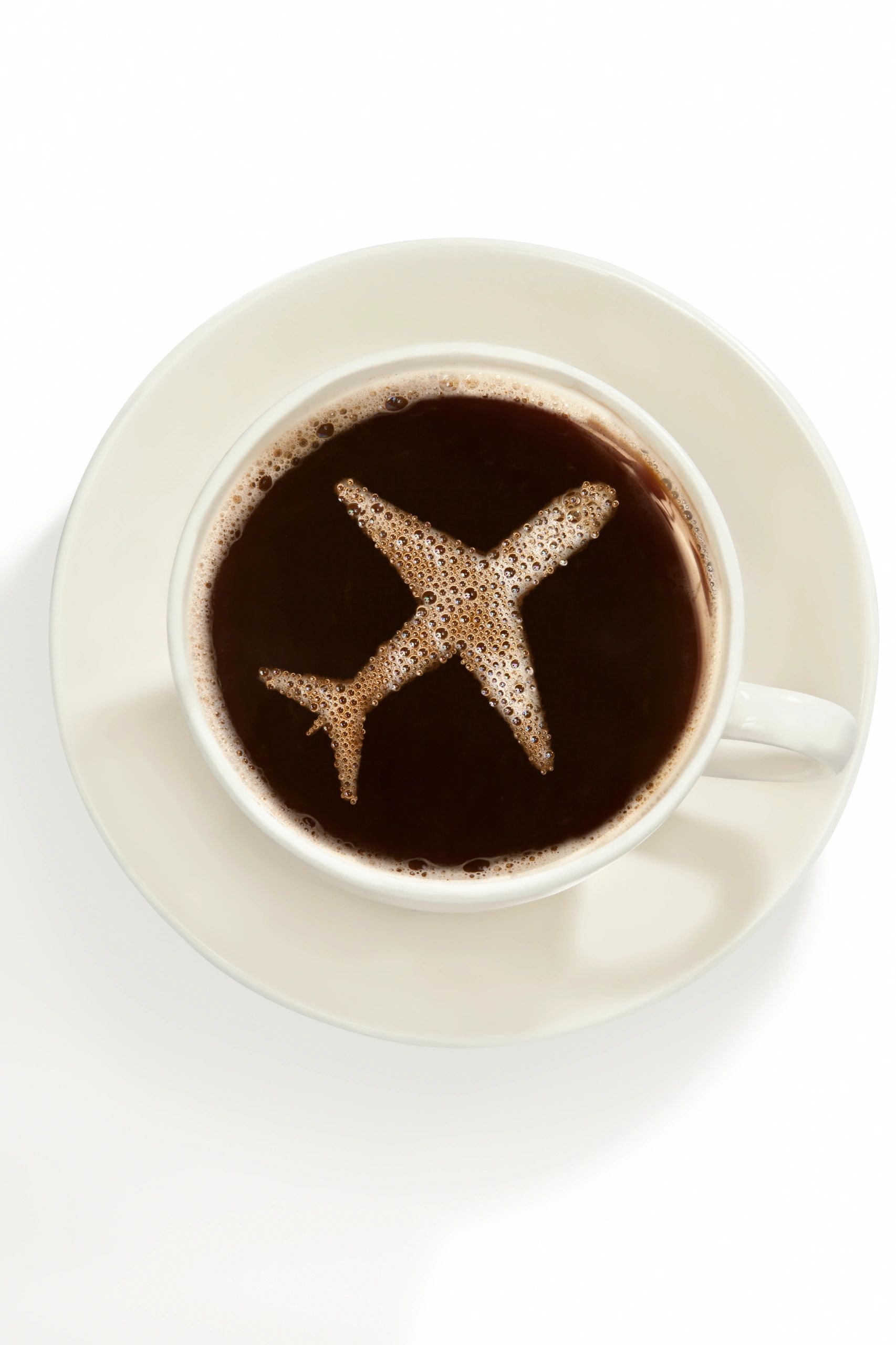 Coffee cup with airplane-shaped foam on top.