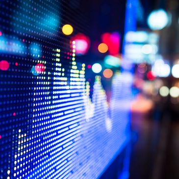 Digital stock market graph displayed on a bright LED screen.