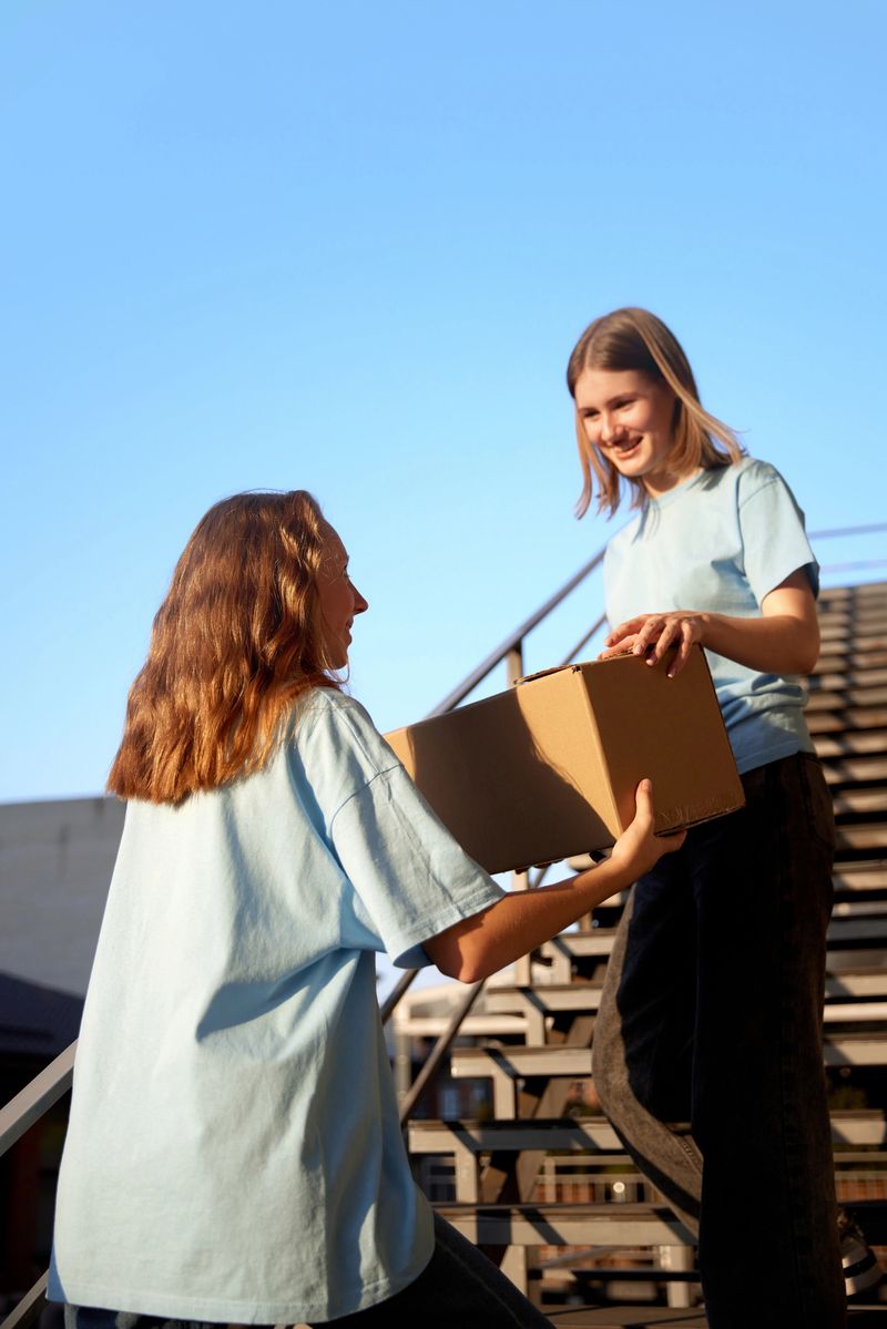 Volunteers standing on stairs with boxes filled with humanitarian help, clothes, goods, food and meds for people and animals in need. Humanitarian aid, assistance and support, social programs concept