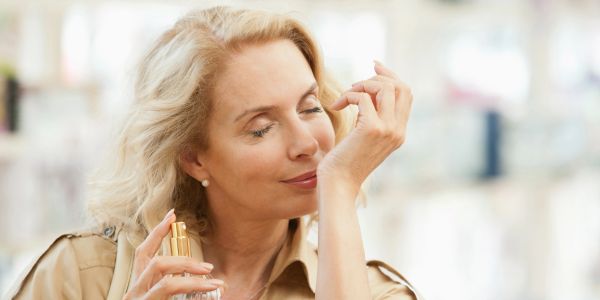 A woman enjoying a fragrance spray.