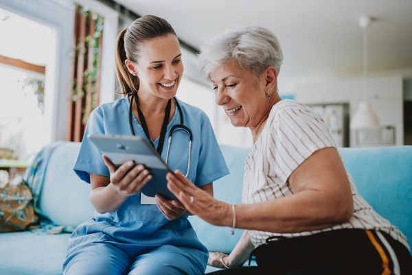 Nurse assisting elderly patient compassionately