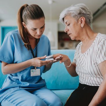 Nurse checking elderly woman's blood oxygen level at home.
