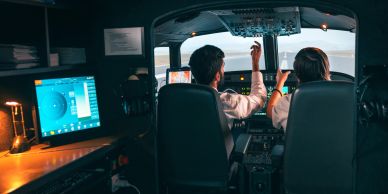 Two pilots operating an aircraft cockpit.