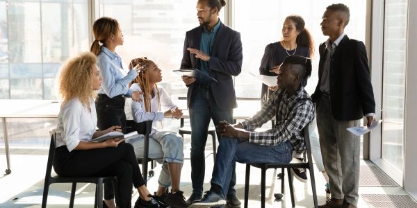 Team of six people having a discussion in an office.