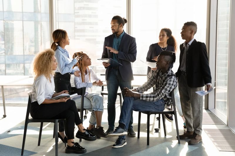 A group of diverse individuals engaged in a mentoring session, sharing ideas and inspiration.