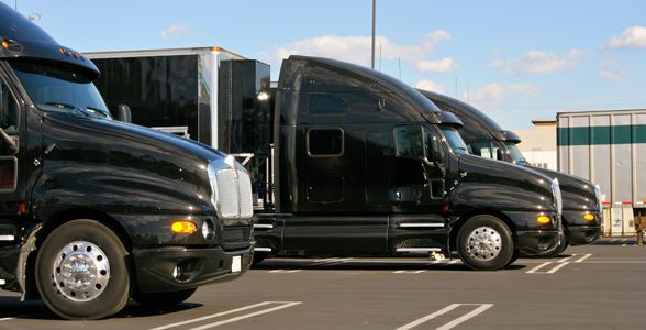 Row of trucks under a cloudy sky.