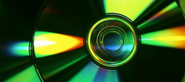 Close-up of a CD reflecting colorful light patterns.