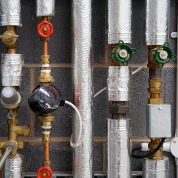 Green underfloor heating pipes arranged on insulation panels in a construction site.