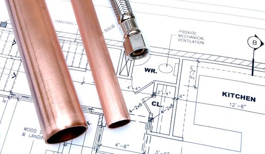 Various plumbing tools and brass fittings on a brown surface.