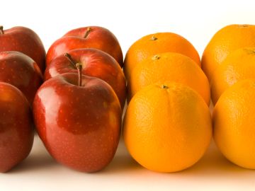 Row of red apples and oranges on white background.