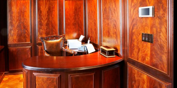 Luxurious wooden office with a classic desk and leather chair.