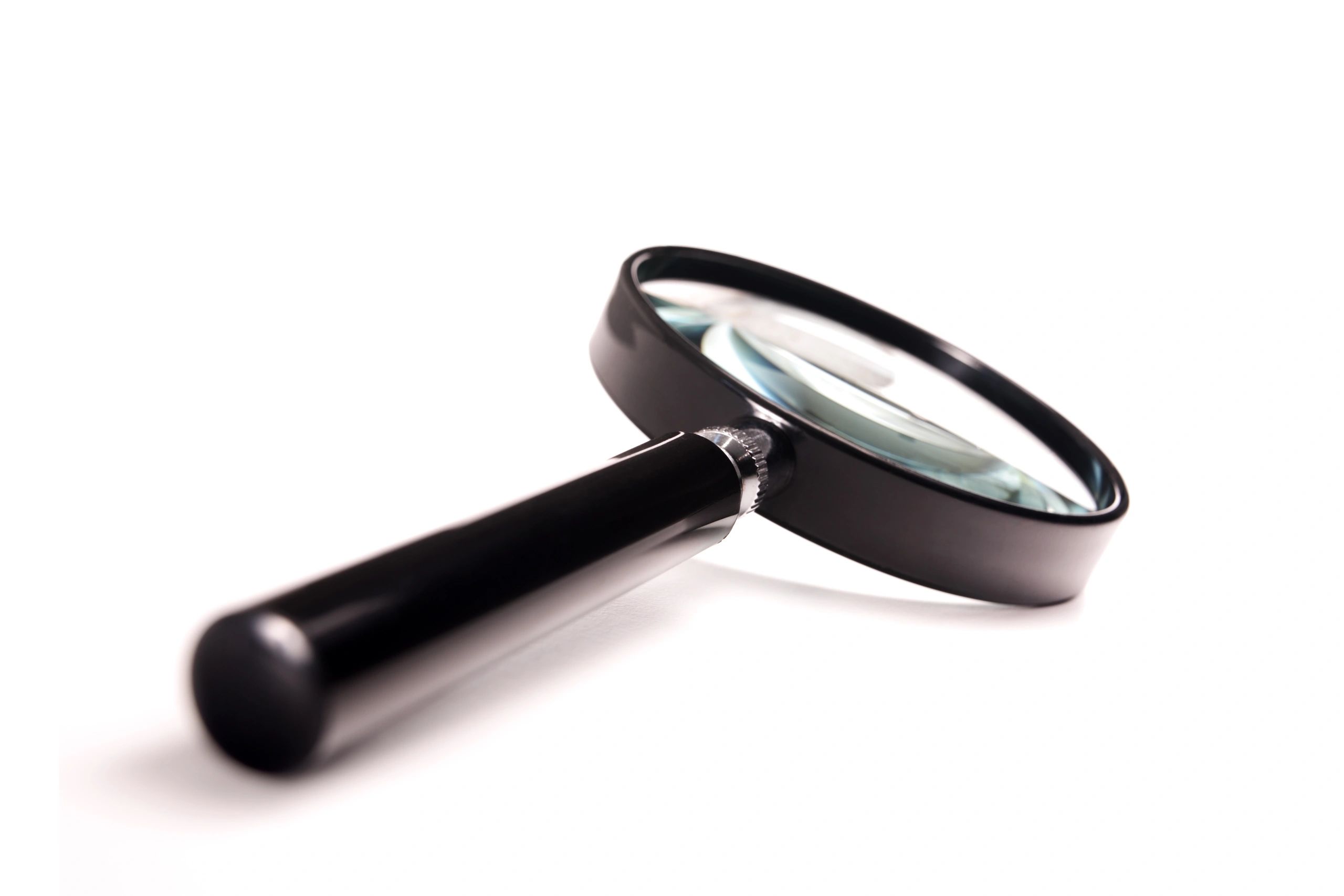 Close-up of a magnifying glass with a black handle on white background.