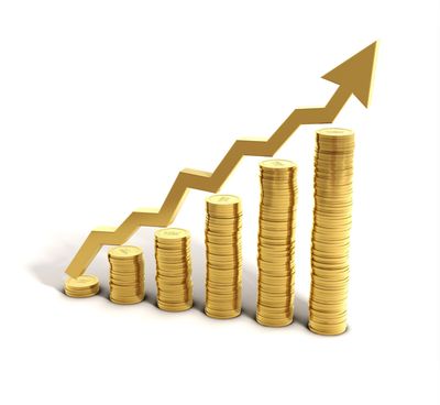 Stacks of gold coins with an upward arrow showing financial growth.
