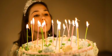 Woman blowing out candles on a birthday cake.