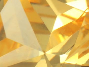 Close-up of a sparkling golden gemstone's facets.
