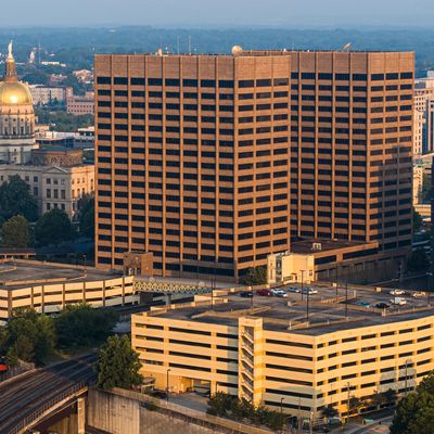 Large office building with parking garage in a city.
