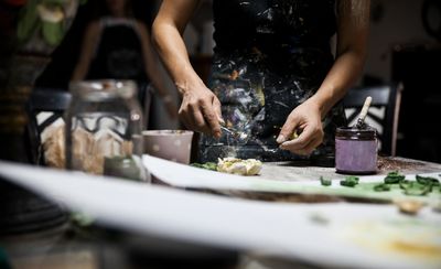 Person working on a creative art project with paint.