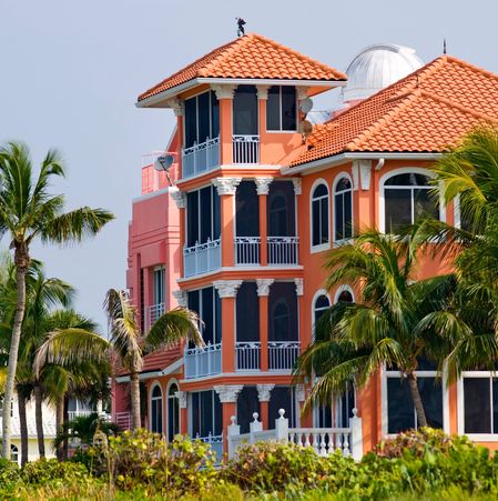 Colorful Mediterranean-style house with palm trees.