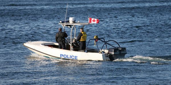 Canadian police officers patrolling on a motorboat.