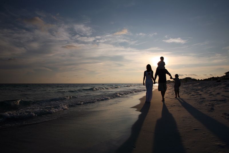 A family walks along the waters edge during a wonderful sunset - So relaxing!
