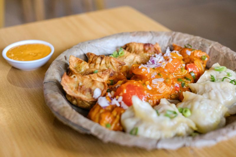 A plate of assorted chicken momos (steamed, fried and chilli sauce dumplings) served on a leaf plate at Tapari Nights, a Nepalese restaurant in Auburn, Sydney - NSW, Australia