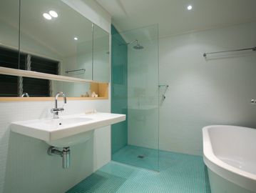 Modern bathroom with glass shower and freestanding tub.