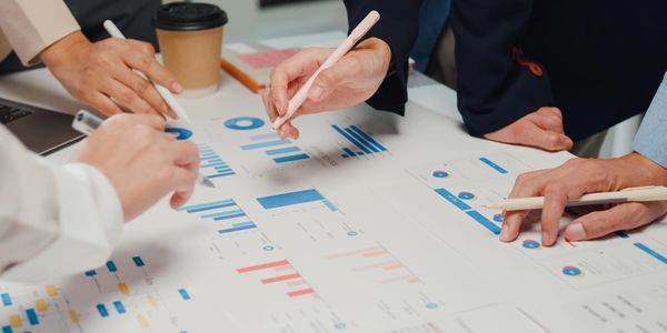 Team analyzing charts and graphs during a business meeting.