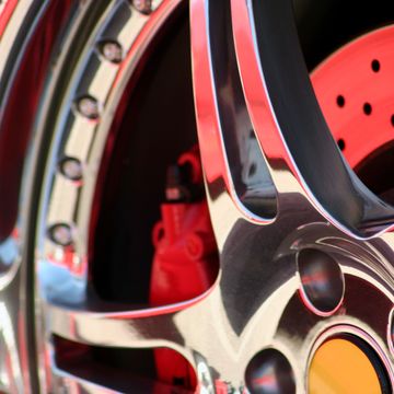 Close-up of a shiny car wheel rim with red brake components.