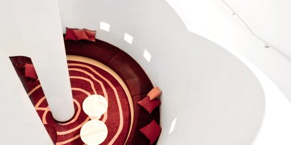 Top view of a circular seating area with red cushions.