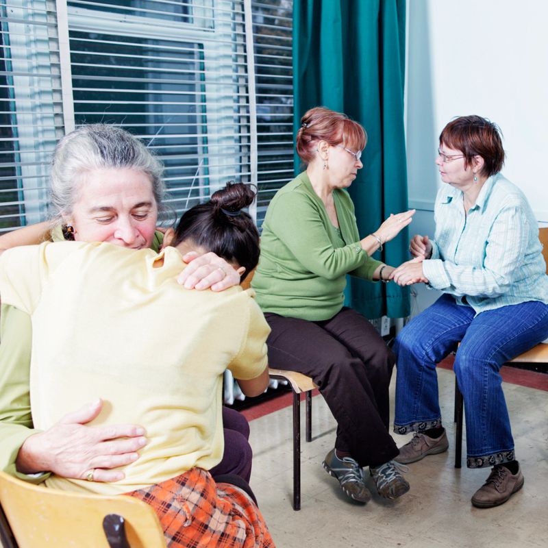 Women consoling each other at a grief counseling session.