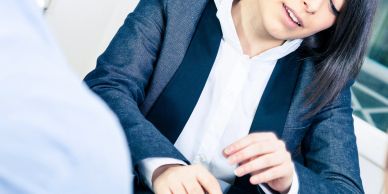 Woman in business attire talking to someone.