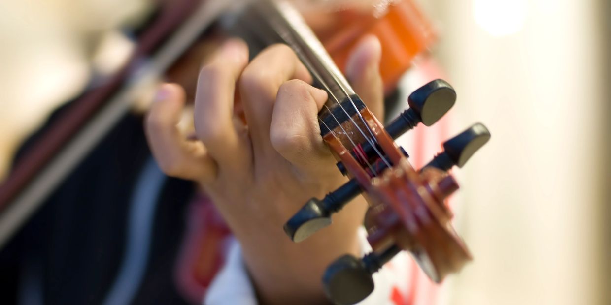 Close-up of hands playing a violin.