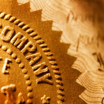 Close-up of a golden company seal with embossed text and design.