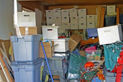 A cluttered storage space filled with boxes and bins.