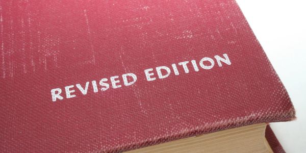 Close-up of a red book labeled 'REVISED EDITION' on the cover.
