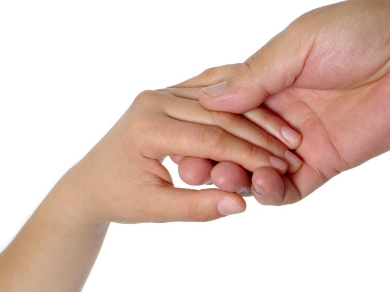 Female's and male's hands holding each other gently