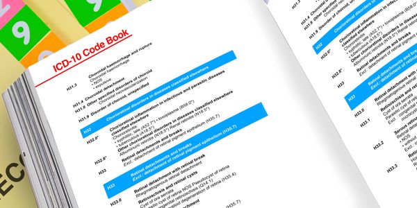 Open ICD-10 Code Book showing detailed medical classification codes with colorful tabs.