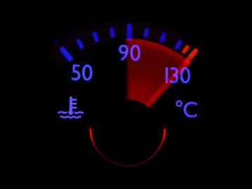 Car engine temperature gauge showing high temperature near 130°C.