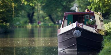 A boat moored on a calm river surrounded by greenery.