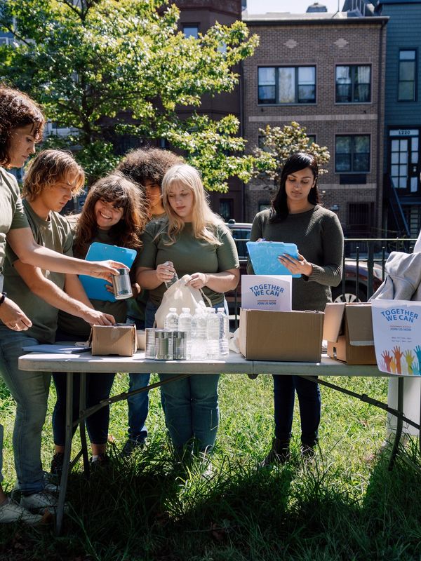 Group volunteering outdoors with donation boxes.
